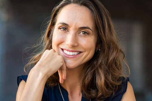 Image of a woman smiling after knowing her dental care cost is affordable, at Capital Dental Center in Washington, DC.