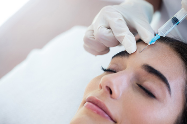 A woman receiving Botox injections from a doctor in Washington, DC office.