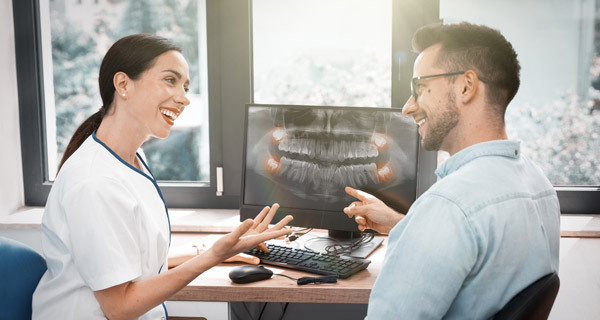 Female dentist discusses digital x-ray results with her patient