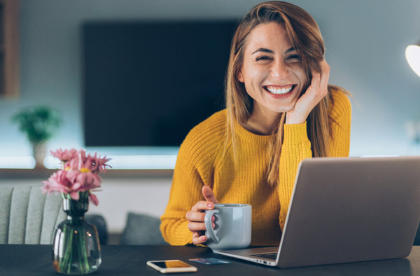 Woman smiling at desk with laptop
